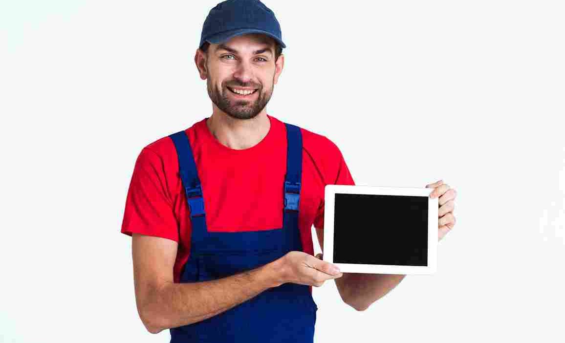 Hard-working courier man holding a tablet during work.