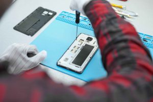 A professional technician is removing screws of mobile